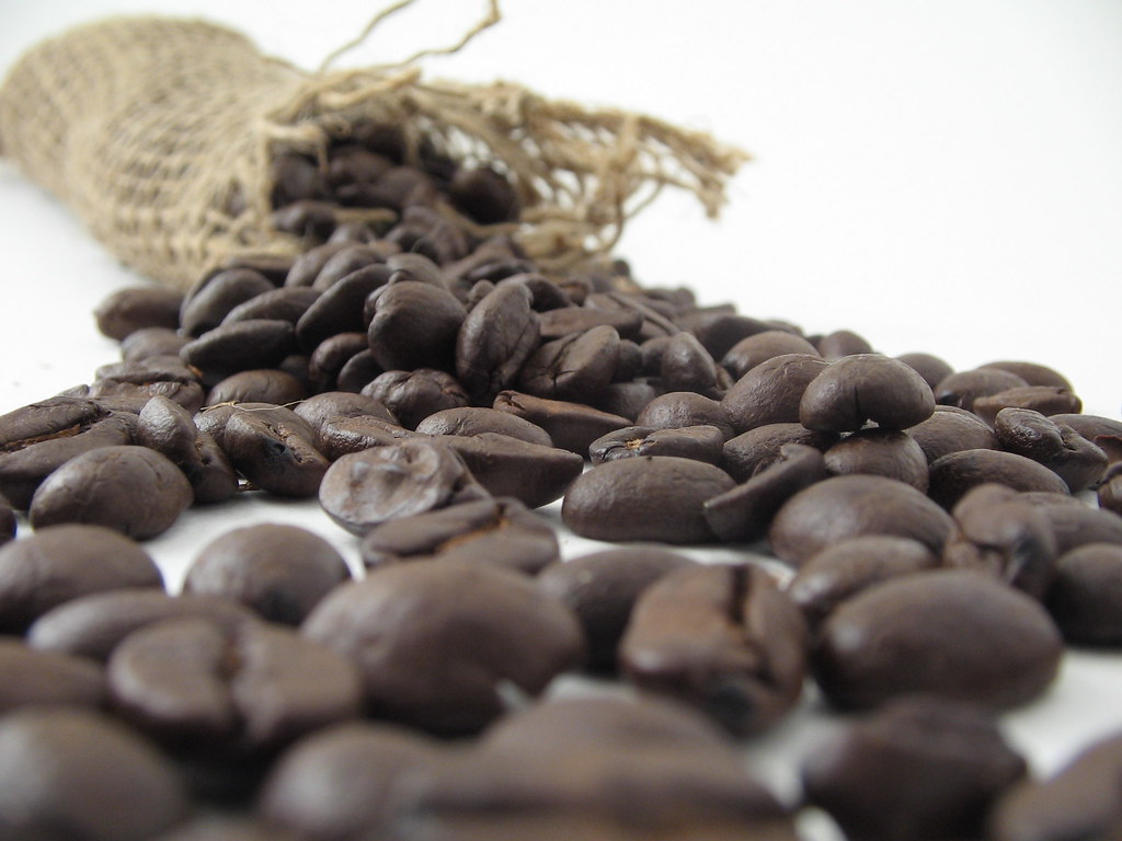 Granos de café derramados sobre una superficie clara